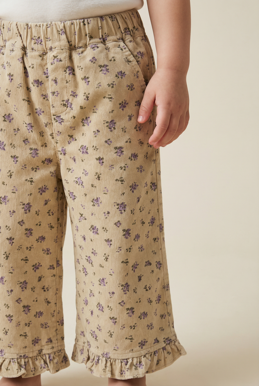 Pantalon en velours côtelé beige à fleurs et ourlet à volants