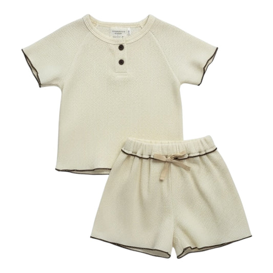 Cream waffle-textured baby top and shorts set with contrast ruffle-edge stitching, displayed flat on a white background.