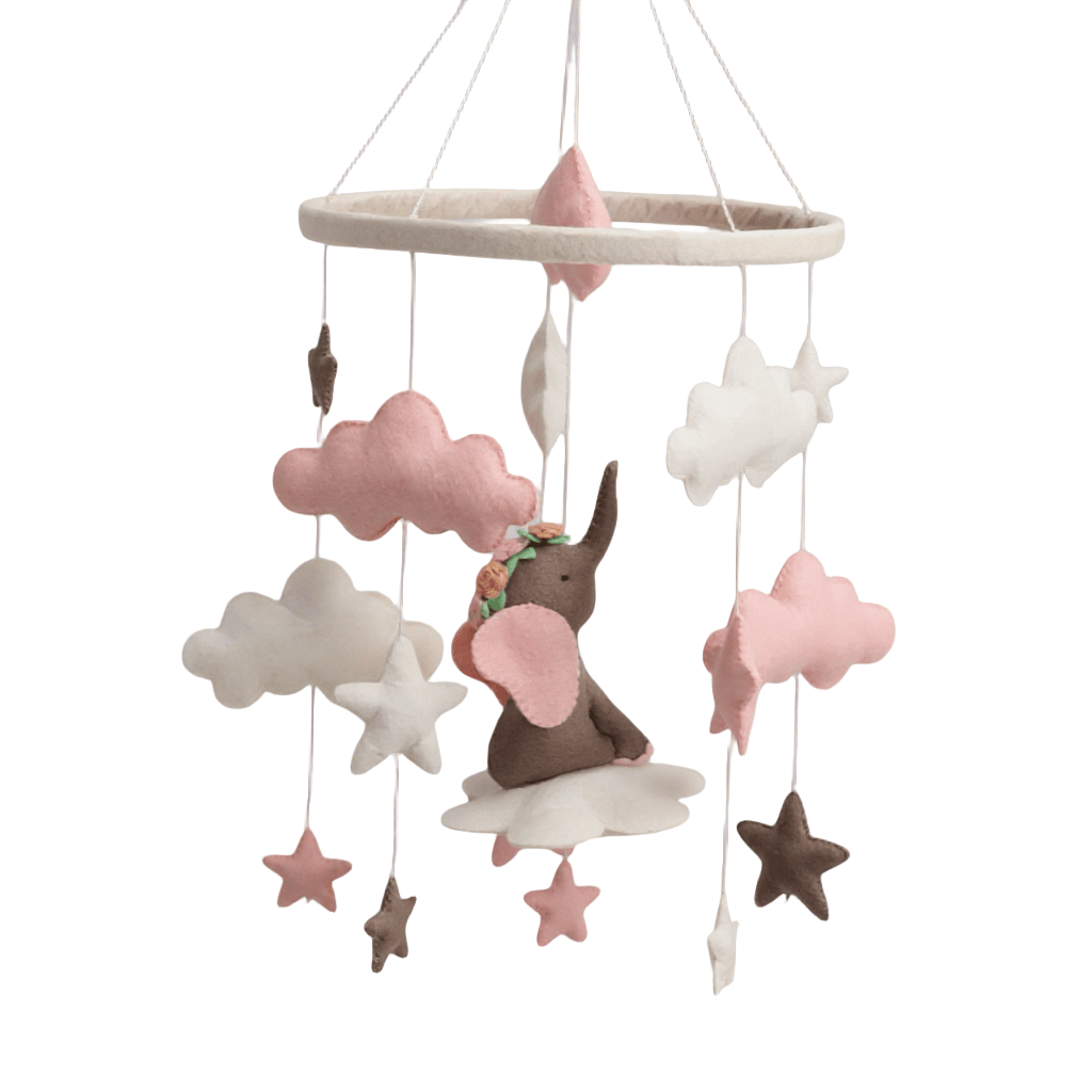 Pink and cream felt cot mobile featuring a hand-felted elephant sitting on a cloud surrounded by stars and clouds, hanging from a padded felt ring on white background.